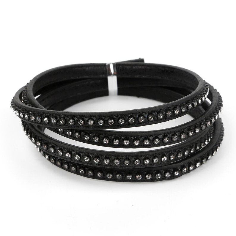 May include: A black leather bracelet with multiple rows of rhinestones.