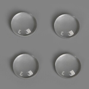 May include: Four clear glass cabochons, each with a smooth, rounded surface.