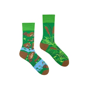 May include: A pair of green socks featuring a brown beaver and green plant design. The socks are made from cotton and are comfortable to wear.