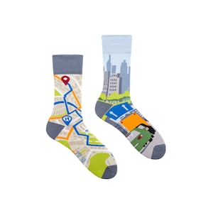 May include: A pair of colourful socks with a city map design. One sock features a map with a red pin and the text "Stop, Look, Listen". The other sock features a city skyline with a yellow bus and the text "Stop, Look, Listen".