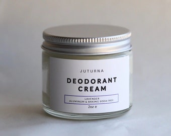 May include: A glass jar with a silver lid containing a white deodorant cream. The label reads "JUTURNA DEODORANT CREAM LAVENDER ALUMINUM & BAKING SODA FREE 2oz e".
