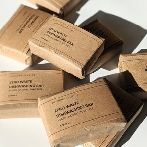 May include: Multiple brown paper wrapped bars labeled "Zero Waste Dishwashing Bar" with the text "Vegan. Natural. Toxic Free." and the size in ounces.