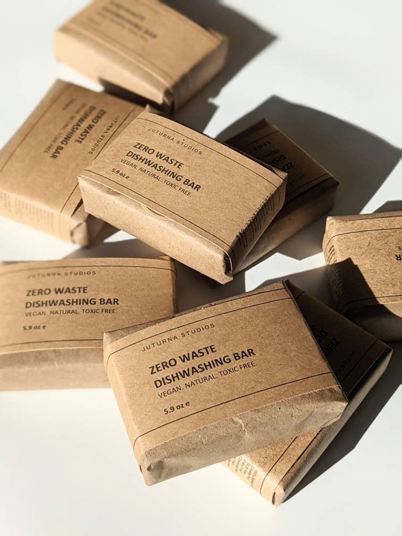 May include: Multiple brown paper wrapped bars labeled "Zero Waste Dishwashing Bar" with the text "Vegan. Natural. Toxic Free." and the size in ounces.