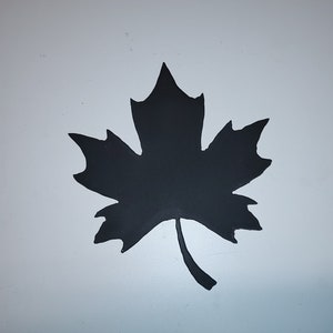 May include: A black silhouette of a maple leaf with a jagged edge. The leaf is on a white background.