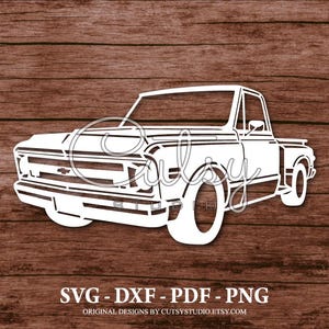 Puede incluir: Diseño recortado en blanco de una camioneta clásica, sobre un fondo de vetas de madera marrón. La camioneta presenta líneas detalladas y una estética vintage. La imagen incluye el texto "SVG - DXF - PDF - PNG".