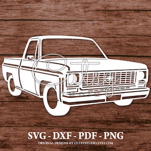 以下が含まれることがあります： グリル、ヘッドライト、荷台が付いたビンテージピックアップトラックの白いシルエット。トラックは木目調の背景の上にあります。