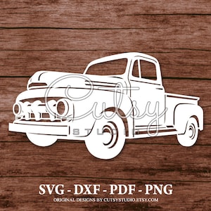 May include: White silhouette of a vintage pickup truck with a large grille and rounded headlights. The truck is facing the viewer and is set against a woodgrain background.
