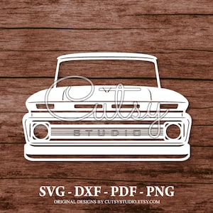 Puede incluir: Silueta blanca de una camioneta vintage con parrilla, faros y capó. La camioneta está de frente. La imagen está sobre un fondo de madera.
