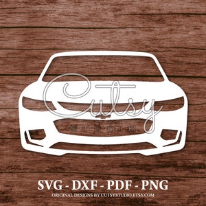 Könnte beinhalten: Weiße Silhouette der Vorderseite eines Autos mit Kühlergrill und Scheinwerfern. Das Bild ist auf einem Holzmaserungshintergrund. Der Text "Cutsy Studio" ist im Bild.