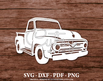 May include: White silhouette of a vintage pickup truck on a brown wood background. The truck has a long hood and a large grille. The image includes the text "SVG - DXF - PDF - PNG" and "ORIGINAL DESIGNS BY CUTSYSTUDIO.ETSY.COM".