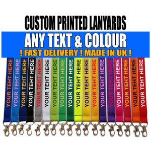 Puede incluir: Una colección de diecisiete cordones de tela en varios colores, incluyendo azul, negro, gris, blanco, verde, amarillo, naranja, rojo, morado y rosa. Cada cordón cuenta con un mosquetón de metal y el texto blanco repetido YOUR TEHT HERE.