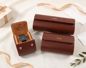 May include: Three brown leather watch cases with gold-tone snap closures. One open case displays a black wristwatch and the text "Your Time Is Priceless" inside. Two closed cases feature personalized gold-tone lettering reading "JAKE" and "DYM" respectively.