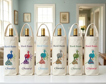 May include: Six off-white canvas wine bottle bags with handles, each featuring a colorful peacock illustration perched on a branch. The text "Bird Bam" is printed above the peacock and "Cheers!" is printed below in matching colored ink.