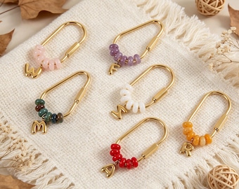 May include: Six gold-toned metal carabiner-style keychains, each featuring a row of small, colorful beads and a single hanging letter charm. The beads are light pink, purple, dark green, white, red, and orange, with letter charms W, F, M, S, A, and R.