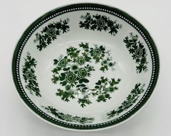 May include: A white ceramic bowl with a green floral pattern. The bowl has a scalloped edge and a wide rim.