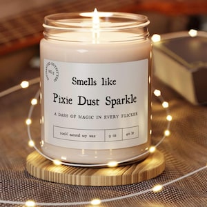 May include: A clear glass candle jar with a white label that reads "Smells like Pixie Dust Sparkle. A dash of magic in every flicker. 100% natural soy wax. 9 oz. 40 hr."