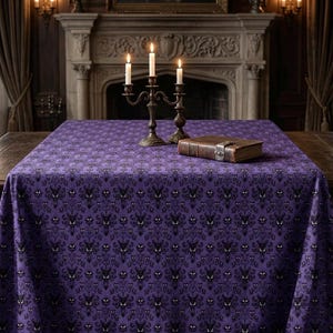 Peut inclure: Une nappe rectangulaire présentant un motif répétitif de style damassé dans des tons de violet et de noir. Le design se compose de motifs symétriques stylisés avec de petits yeux blancs brillants intégrés dans les formes florales sombres.