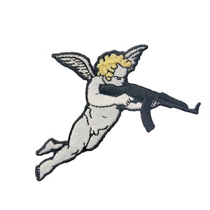 May include: A white cherub with blonde hair and wings holding a black rifle. The cherub is flying in the air.