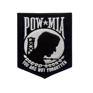 Può includere: Toppa ricamata nera con una silhouette bianca della testa di un soldato, un emblema POW MIA e il testo "You Are Not Forgotten".