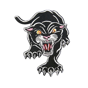 Op de afbeelding: Gestikt patch van een zwarte panter met een woeste uitdrukking, met gele ogen, witte tanden en een roze neus.