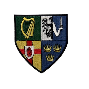 May include: A green, white, red, and blue embroidered patch with the coat of arms of Ireland. The patch features a harp, a bird, a hand, and three crowns.