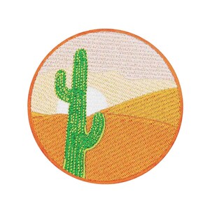 May include: A round embroidered patch featuring a green cactus in a desert landscape. The background is orange and yellow with a white sun.