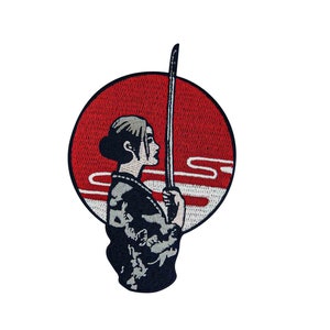May include: An embroidered patch featuring a woman holding a sword in front of a red circle with a white wave design.