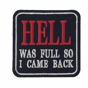May include: A black and white embroidered patch with the text "HELL WAS FULL SO I CAME BACK" in red and white lettering.
