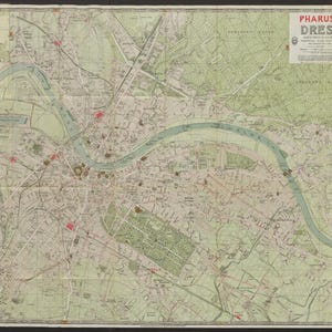 May include: A vintage map of Dresden, Germany, with the title "PHARUS-PLAN DRESDEN" in the upper right corner. The map features detailed street layouts, green areas, and a prominent river running through the city. The map is framed in black.