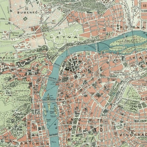 Op de afbeelding: Een vintage kaart van Praag, Tsjechi&euml;, die de stadsdelen en bezienswaardigheden laat zien. De kaart is gedrukt in tinten groen, bruin en roze, met blauwe lijnen die rivieren en kanalen voorstellen. De kaart bevat de namen van de stadsdelen, zoals "BUBENEČ", "LETNA", "HRADCANY", "MALA STRANA", "STAR&Eacute; MESTO", "NOV&Eacute; MESTO", "VINOHRADY" en "SMICHO".