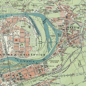Op de afbeelding: Een vintage kaart van Praag, Tsjechi&euml;, die de indeling van de stad en belangrijke bezienswaardigheden laat zien. De kaart is gedrukt in tinten groen, blauw en bruin, met tekstlabels in het Tsjechisch.