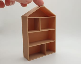 May include: A small, light brown, wooden shelf unit with five shelves. The shelf unit is shaped like a house with a pitched roof.