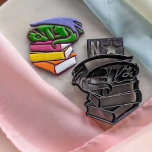 Puede incluir: Una taza de cerámica blanca con un asa negra y el texto "But First, Coffee" en negrita negra. La taza se encuentra sobre un fondo borroso, sugiriendo un ambiente acogedor.