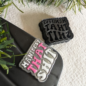 Peut inclure: Deux épingles décoratives avec l'expression "MANIFEST THAT SHIT" dans une police rétro. Une épingle a une palette de couleurs rose et blanche avec une bordure argentée scintillante. L'autre épingle est noire.