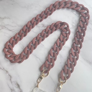 May include: A brown silicone phone chain with gold clasps. The chain is made of thick, chunky links and is designed to be worn around the neck.