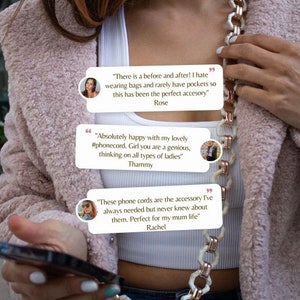 May include: A close-up of a person wearing a white tank top and a pink fuzzy jacket. The person is holding a black phone and a white and gold chain necklace. The image includes three text bubbles with customer reviews about the necklace. The text in the bubbles reads: "There is a before and after! I hate wearing bags and rarely have pockets so this has been the perfect accessory" Rose, "Absolutely happy with my lovely #phonecord. Girl you are a genius, thinking on all types of ladies" Thammy, and "These phone cords are the accessory I've always needed but never knew about them. Perfect for my mum life" Rachel.