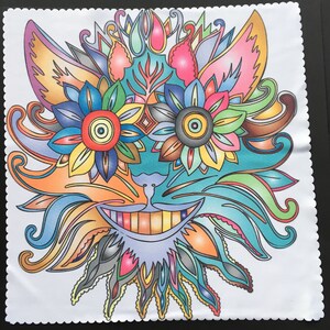 May include: A colorful, whimsical design featuring a smiling cat face with floral elements. The artwork uses a variety of bright colors, including orange, blue, green, and pink, creating a vibrant and playful aesthetic. The design is on a white, scalloped-edge cloth.