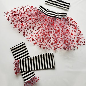 May include: A black and white striped headband, a black and white striped leg warmer with red heart tulle trim, and a red heart tulle skirt with a black and white striped waistband.
