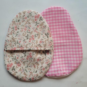 May include: Two fabric pot holders, one with a floral pattern and the other with a pink and white gingham pattern.