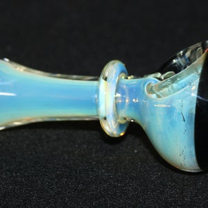 May include: A glass pipe with a blue and white opalescent finish. The bowl is black with a green rim.