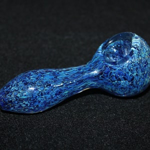 May include: A blue glass pipe with a marbled pattern. The pipe is made of glass and has a round bowl and a long stem.