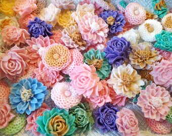 May include: Assortment of colorful handmade soap flowers in various shapes and sizes. The flowers are made to look like roses, daisies, and other floral designs.