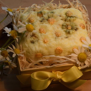 May include: A yellow and white soap bar with a daisy design, in a small wooden box with straw and a yellow ribbon.
