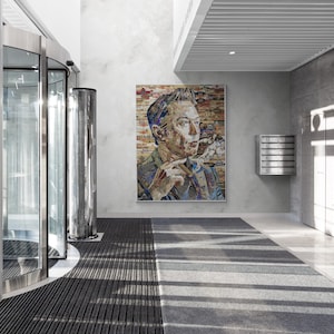 Op de afbeelding: Interieur van een moderne kantoorlobby met een groot portret van een man die een sigaar rookt. De lobby heeft een draaideur, een grijs en zwart gestreept tapijt en een brievenbus.