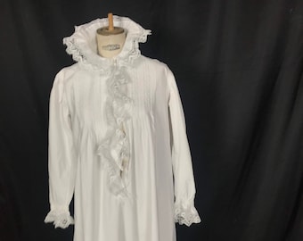 May include: A white cotton nightgown with long sleeves and a lace collar and cuffs. The gown has a ruffled trim down the front and is gathered at the waist.