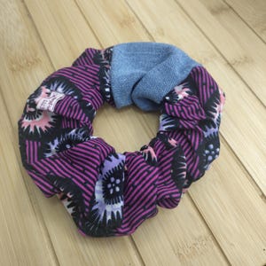 Può includere: Un elastico per capelli con un mix di tessuti. Il tessuto principale presenta un motivo nero e magenta con accenti floreali. È inclusa anche una sezione di denim blu chiaro. Per lo styling dei capelli.