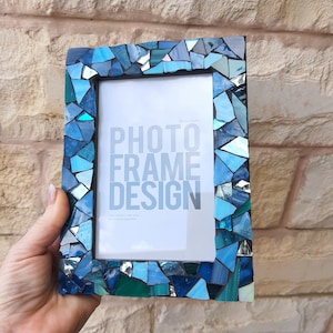 May include: A blue mosaic photo frame with a white mat and the text "PHOTO FRAME DESIGN" printed on the mat. The frame is made of small pieces of glass in shades of blue, green, and turquoise.