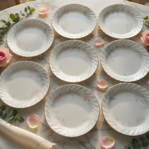 May include: A white ceramic mug with a black handle and the text "But First, Coffee" in a handwritten style. The mug is on a white surface. The mug is approximately 4 inches tall.