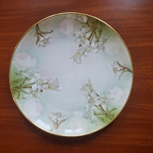 May include: A set of three ceramic mugs with a speckled, matte finish. The mugs are in shades of cream, light gray, and dark gray. Each mug has a simple, minimalist design, perfect for coffee or tea.