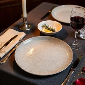 May include: A set of three ceramic nesting bowls in shades of blue, green, and white. The bowls feature a speckled glaze and a simple, modern design. The largest bowl measures approximately 8 inches in diameter.